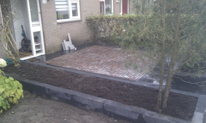 tuinmetverhoogdeborderoudegebakkenwaalformatenincombinatiemetchineeshardsteen.jpg